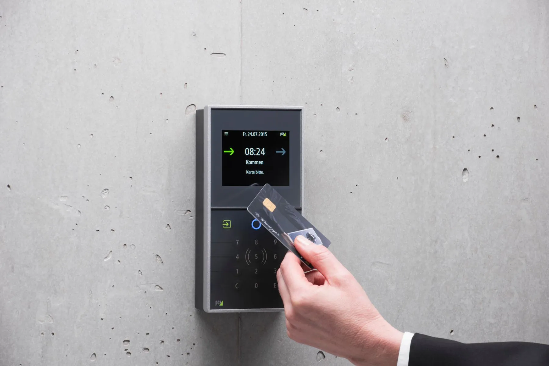 Person tapping an access card on a wall-mounted reader