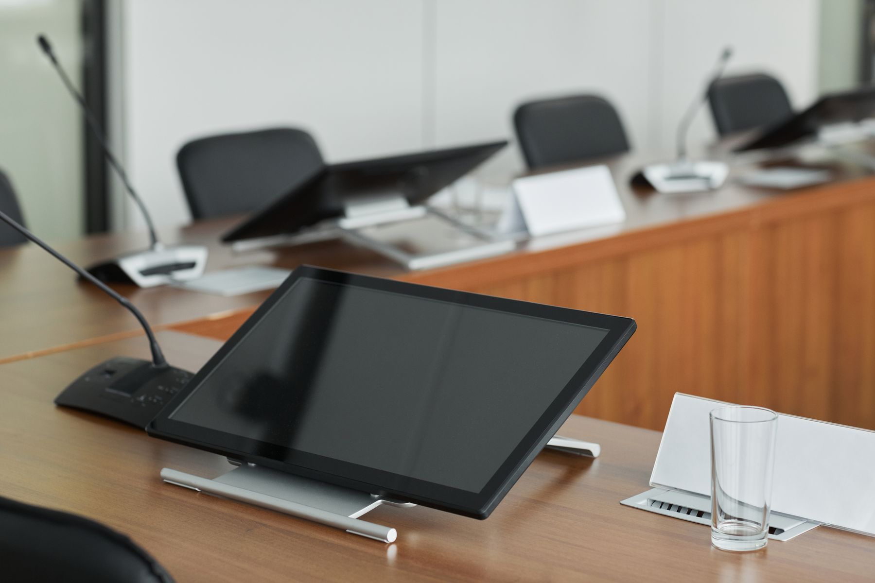 Conference room table with microphones and a display