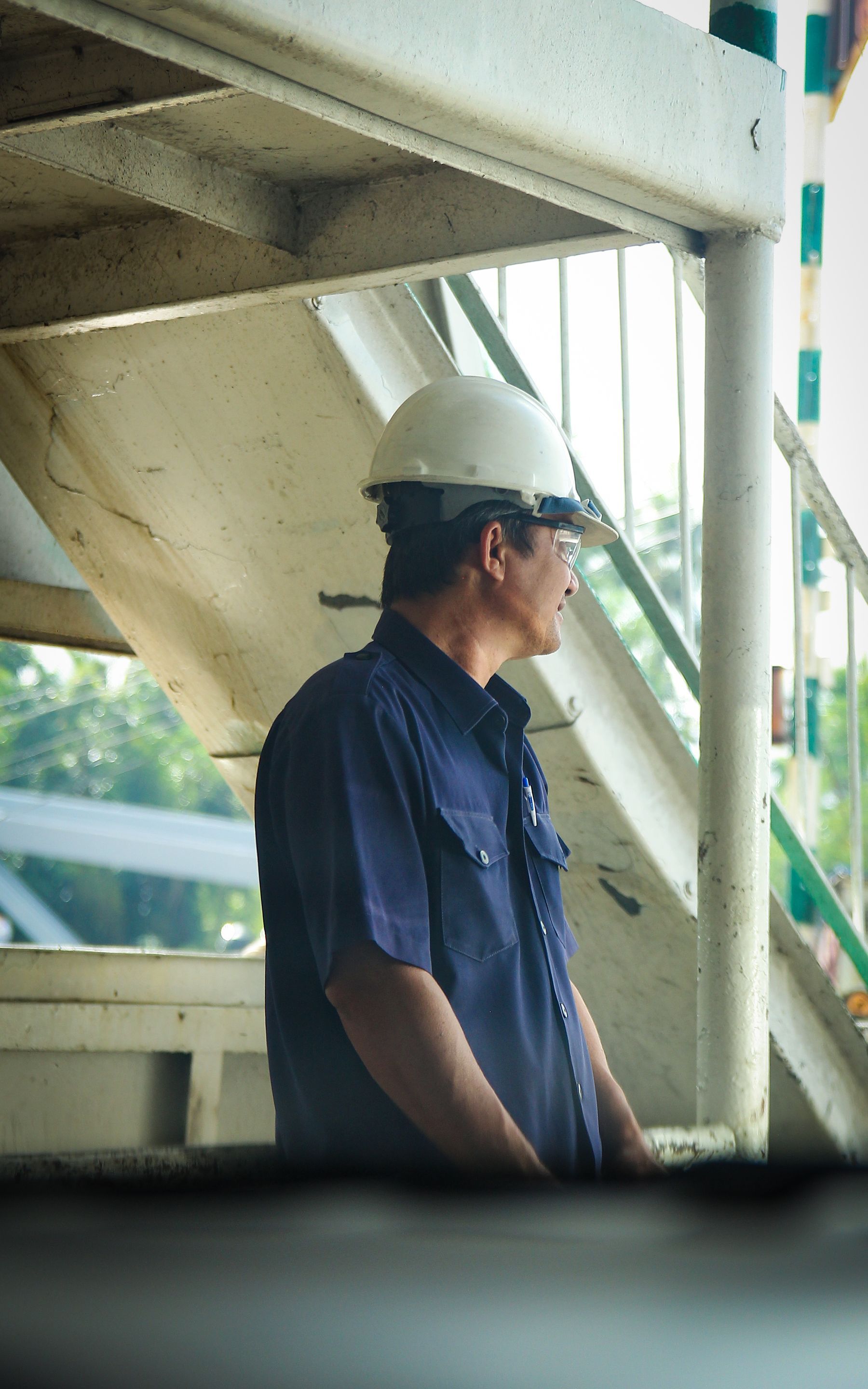 Technician in work gear standing by a stairway