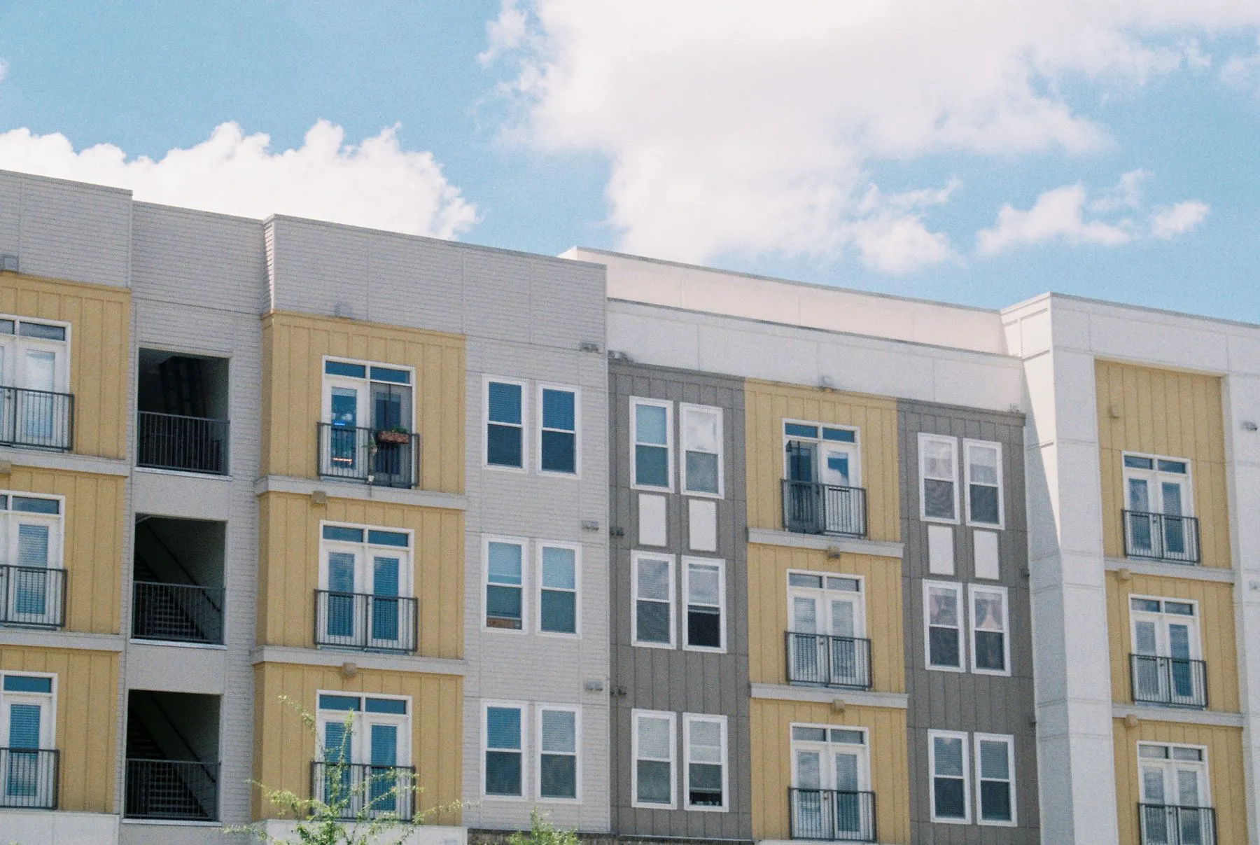 Modern mid-rise apartment building under a blue sky