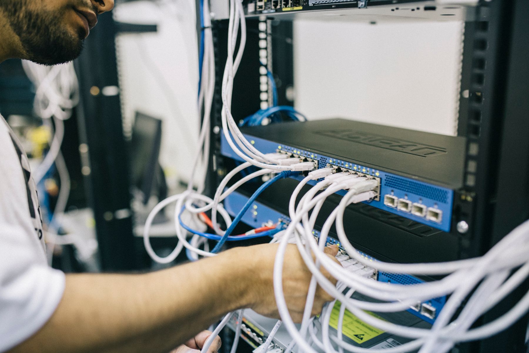 Technician dressing patch cables in a network rack
